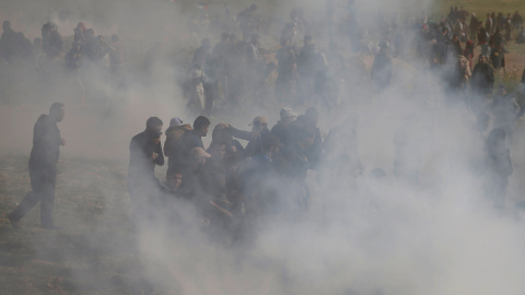 Los palestinos huyen del gas lacrimógeno disparado por las tropas israelíes durante los enfrentamientos, durante una protesta a lo largo de la frontera de Israel con Gaza, exigiendo el derecho a regresar a su tierra natal, al este de la ciu