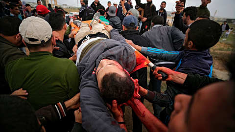 Varios palestinos trasladan a un compañeros fallecido de un disparo en la cabeza durante los enfrentamientos con soldados israelíes en el este de Beit Hanun.- EFE/Mohammed Saber