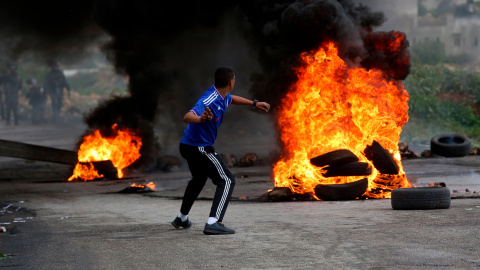 Un palestino lanza una piedra durante los enfrentamientos con soldados israelíes en la ciudad cisjordana de Ramala.-EFE/Alaa Badarneh