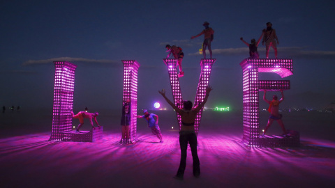 Los participantes se suben a una instalación de arte en el festival de arte y la música Burning Man 2015 "Carnaval de los Espejos" en el Desierto de Nevada. REUTERS / Jim Urquhart