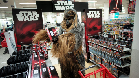 Un fan vestido como Chewbacca mirando un juego de la película Star Wars: The Force Awakens justo antes de la medianoche del 'Viernes de la Fuerza' en Sydney, 4 de septiembre de 2015. REUTERS / Jason Reed