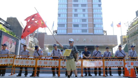 Manifestantes a favor de la independencia de Taiwán ondean una bandera china agujereada en Taipei. - AFP