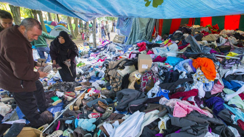 Centenares de inmigrantes buscan ropa en un campamento improvisado en las afueras de la Oficina de Extranjería en Bruselas./ REUTERS