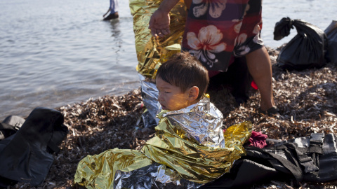 Niño afgano refugiado de 2 años lleva una manta térmica momentos después de llegar a la isla griega de Lesbos, 4, 2015. REUTERS / Dimitris Michalakis
