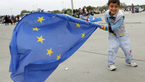Un niño agita la bandera europea tras lograr cruzar la frontera entre Hungría y Austria. /REUTERS