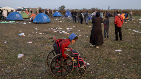 Un niño juega con una silla de ruedas en un campo cerca del pueblo de Röszke, Hungría, 5 de septiembre de 2015. REUTERS / Marko Djurica