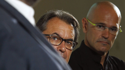 El president de la Generalitat y candidato numero 4 de Junts pel Sí, Artur Mas, y el candidato numero 1 Raul Romeva (d) escuchan al candidato numero 5 Oriol Junqueras durante el acto de presentación del programa electoral de la coalición. E