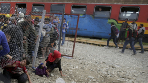 La Policía de Macedonia intenta parar a los inmigrantes que pasan la valla por debajo con el fin de coger un tren y emprender su viaje a Serbia y llegar a Hungría, para tener asilo./ REUTERS/ Stoyan Nenov