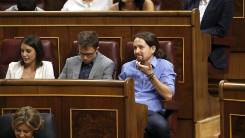 El líder de Podemos, Pablo Iglesias (d) el portavoz del grupo, Íñigo Errejón,c, y su jefa de gabinete, Irene Montero (i), en sus escaños al inicio de la segunda sesión del debate de investidura del líder del PP, Mariano Rajoy, esta mañana e