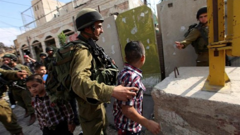 Soldados israelíes detienen a niños palestinos - EFE/ABED AL HASHLAMOUN Soldados israelíes detienen a niños palestinos - EFE/ABED AL HASHLAMOUN