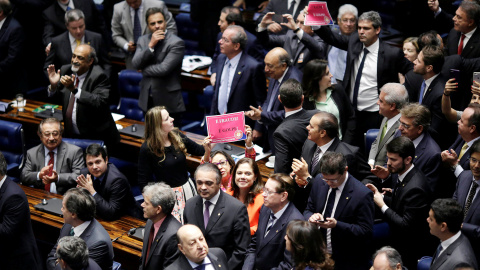 Varios senadores sujetan carteles contrarios al "golpe" contra Rousseff durante la votación en la Cámara. - REUTERS Varios senadores sujetan carteles contrarios al "golpe" contra Rousseff durante la votación en la Cámara. - REUTERS
