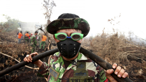 Un soldado indonesio utiliza gafas de natación para proteger sus ojos contra el humo mientras ayuda a apagar un incendio en una zona forestal de Parit Indah Village, Kampar, provincia de Riau, Indonesia, 8 de septiembre de 2015. REUTERS / Y