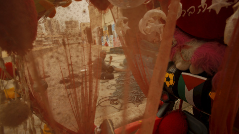 Se ve a un pescador palestino a través de una tela mientras prepara una red durante una tormenta de arena en el Puerto de la ciudad de Gaza, 9 de septiembre de 2015. REUTERS / Suhaib Salem