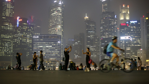 La gente toma fotos con el distrito central de negocios de Singapur de fondo. REUTERS