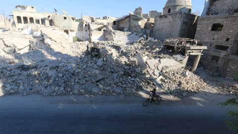 Un niño monta en bicicleta cerca de los escombros de los edificios dañados en el distrito de Al Maadi de Alepo, (Siria).- Abdalrhman Ismail (REUTERS) Un niño monta en bicicleta cerca de los escombros de los edificios dañados en el distrito de Al Maadi de Alepo, (Siria).- Abdalrhman Ismail (REUTERS)