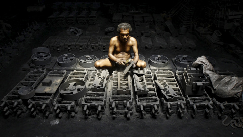 Un obrero trabaja en la fabricación de piezas de hierro en una compañía a las afueras de Calcuta. REUTERS