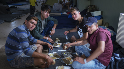 Un grupo de refugiados comiendo el menú preparado por los voluntarios.-PROYECTO ZAPOREAK