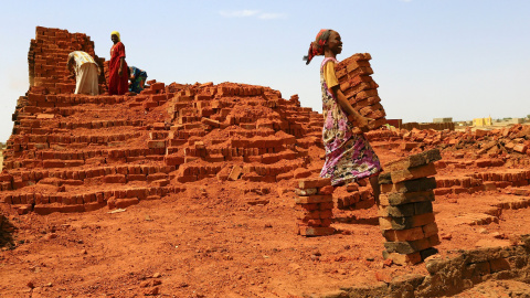 Una mujer lleva adobes en el campamento de Abu en Al Fashir, capital de Darfur del Norte, Sudán. REUTERS / Mohamed Abdallah Nureldin