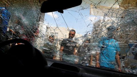 Palestinos rodean el coche de Mustafa Nimer, que fue asesinado a tiros esta mañana por las fuerzas de seguridad israelíes, en el campo de refugiados de Shuafat, cerca de Jerusalén. REUTERS / Ammar Awad