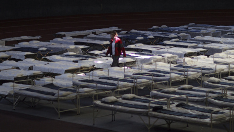 Una mujer camina entre una multitud de camas en un nuevo centro de acogida de emergencia para refugiados en el August Scherttner Hall en Hanau (Alemania) hoy, 14 de septiembre de 2015. El centro puede acoger hasta 1.000 refugiados. EFE/Fred