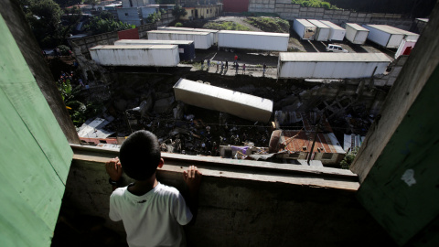 Un niño mira en el lugar donde se produjo un deslizamiento de tierra  causando varias bajas en Villanueva, Guatemala. REUTERS/Saul Martinez