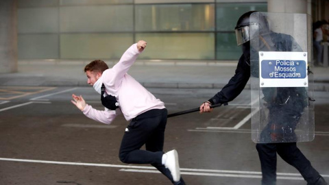 14/10/2019.- Miembros de los Mossos d'Esquadra cargan contra los centenares de personas que se agolpan ante el Aeropuerto del Prat. EFE/Toni Albir