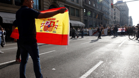 Un hombre con una bandera de España se encara con los centenares de personas que cortan la céntrica Via Laietana de Barcelona en protesta por la sentencia del procés en la que se condena a los líderes independentistas a penas de entre 9 y 1