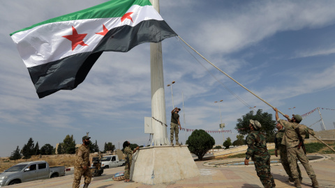 14/10/2019 - Los combatientes rebeldes sirios respaldados por Turquía alzan la bandera de la oposición siria en la ciudad fronteriza de Tel Abyad. REUTERS / Khalil Ashawi 14/10/2019 - Los combatientes rebeldes sirios respaldados por Turquía alzan la bandera de la oposición siria en la ciudad fronteriza de Tel Abyad. REUTERS / Khalil Ashawi
