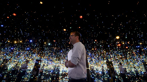 Un asistente en el Yayoi Kusama "Infinity Mirrored Room" en el interior del Broad Museum durante una presentación a la prensa en Los Ángeles, California. El nuevo museo construido por Eli y Edythe Broad, abrirá con su colección de arte mode