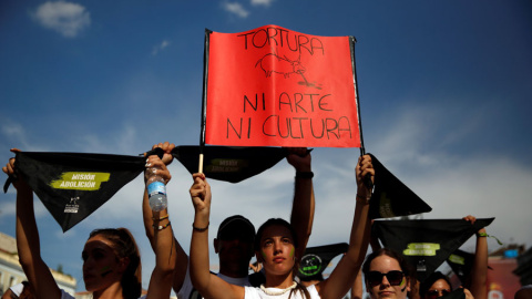 Una mujer porta una pancarta durante la manifestación por la abolición de las fiestas taurinas. REUTERS/Susana Vera