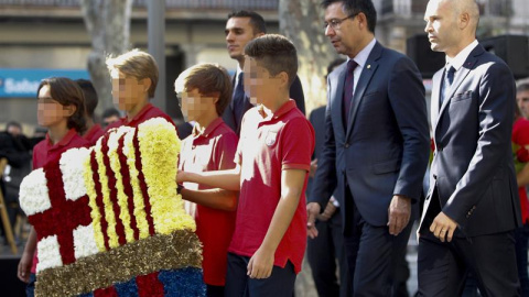 La comitiva del FC Barcelona, encabeada por el presidente, Josep María Martomeu (2d), y el judador Andrés Iniesta (d), asiste a la tradicional ofrenda floral al monumento de Rafael Casanova, dentro de los actos conmemorativos de la Diada na
