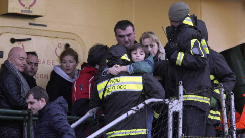 Un bombero baja a un niño del barco "Spirit of Piraeus" a su llegada al puerto. REUTERS/Stringer