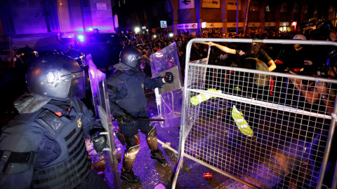 Los Mossos se enfrentan a los manifestantes con las vallas entre medias en las calles céntricas de Barcelona. /REUTERS