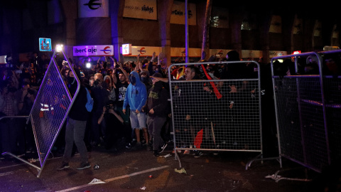 Los manifestantes apartan las vallas situadas para impedir su avance en las calles del centro de Barcelona durante sus protestas. /REUTERS