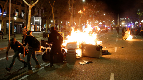 Contenedores ardiendo entre varios manifestantes y los Mossos durante las protestas en el centro de Barcelona. /REUTERS