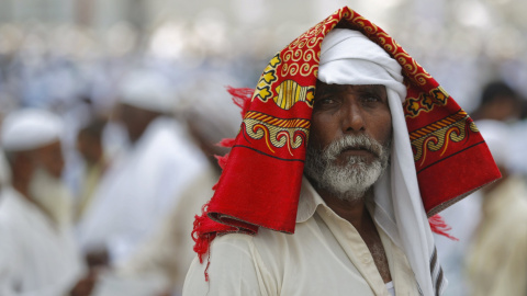 Un peregrino musulmán con su alfombra de oración en la cabeza, después de asistir al rezo del viernes fuera de la Gran mezquita de La Meca. REUTERS