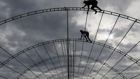 Obreros trabajan en postes de hierro durante la construcción de un escenario para un programa en Colombo. REUTERS
