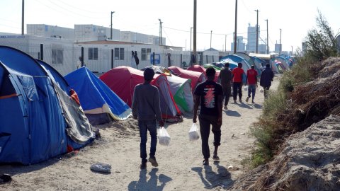 Varias personas pasean por el interior de 'La Jungla' de Calais. - REUTERS Varias personas pasean por el interior de 'La Jungla' de Calais. - REUTERS