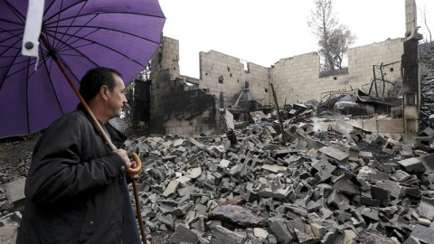 El presidente de la junta vecinal de San Pedro de Paradela, Manolo Ruiz junto a parte de su casa quemada por el incendio originado ayer en Bárcena de la Abadía que puso en jaque a las poblaciones de Fresnedelo, San Pedro de Paradela y Argay
