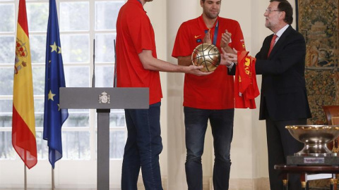 Pau Gasol, junto a Felipe Reyes, le entrega un balón de oro a Mariano Rajoy en La Moncloa. /EFE Pau Gasol, junto a Felipe Reyes, le entrega un balón de oro a Mariano Rajoy en La Moncloa. /EFE