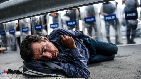 Un migrante descansa delante de una barricada de la policía después que los antidisturbios turcos bloquearan la carretera en dirección a Edirne, el 21 de septiembre de 2015, de Estambul. AFP PHOTO / OZAN Kose