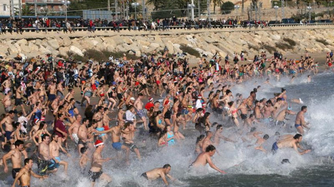 Varios centenares de personas se lanzan al agua para despedir el año en el tradicional año de la San Silvestre de Tarragona, que este año ha llegado a su 30ª edición.  EFE