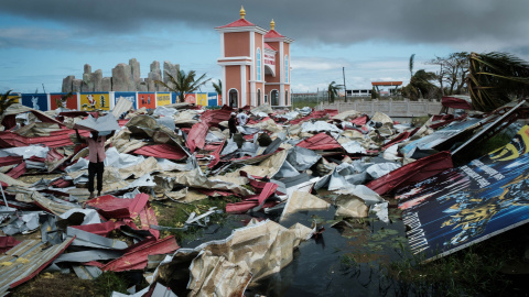 Personas recolectan láminas de metal de un supermercado dañado para reconstruir sus casas destruidas por el ciclón Idai en Beira, Mozambique | AFP/ Yasuyoshi Chiba Personas recolectan láminas de metal de un supermercado dañado para reconstruir sus casas destruidas por el ciclón Idai en Beira, Mozambique | AFP/ Yasuyoshi Chiba