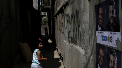 Una niña camina por una calle con propaganda electoral peronista a las afueras de Buenos Aires.- REUTERS/ RICARDO MORAES Una niña camina por una calle con propaganda electoral peronista a las afueras de Buenos Aires.- REUTERS/ RICARDO MORAES