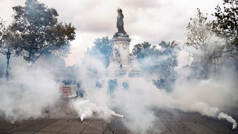 Vista de varios policías detrás de los botes de gas lacrimógenos empleados contra los manifestantes durante una manifestación contra la nueva reforma laboral en París.- EFE/Etienne Laurent