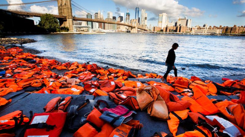 Vista de cientos de chalecos salvavidas de refugiados recogidos en las playas de Chios (Grecia) en la orilla del río Este en Brooklyn, Nueva York, Estados Unidos. EFE/Justin Lane