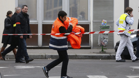 Un trabajador sanitario pasa cerca de las oficinas del semanario satírico francés 'Charlie Hebdo' tras el ataque contra la redacción que ha provocado  doce muertos, entre ellos dos policías. EFE/Ian Langsdon