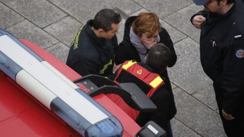 Una mujer es atendida por un bombero cerca de las oficinas de la revista 'Charlie Hebdo'. REUTERS/Christian Hartmann
