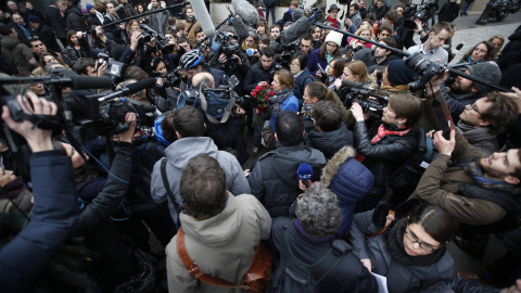 Las cámaras y los periodistas rodean a una mujer que lleva un ramo de rosas a las oficinas de 'Charlie Hebdo', tras el atentado que ha costado la vida a diez periodistas y dos policías. REUTERS/Charles Platiau