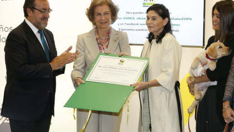 El presidente de la ONCE, Miguel Carballeda, y la reina Sofía entregan un diploma a Teresa Domínguez, en cuyo familia se han educado 28 cachorros de perros guía en los últimos 19 años, en un acto con motivo del 25 aniversario de la Fundació